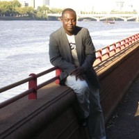 Person leaning on bridge in front of water