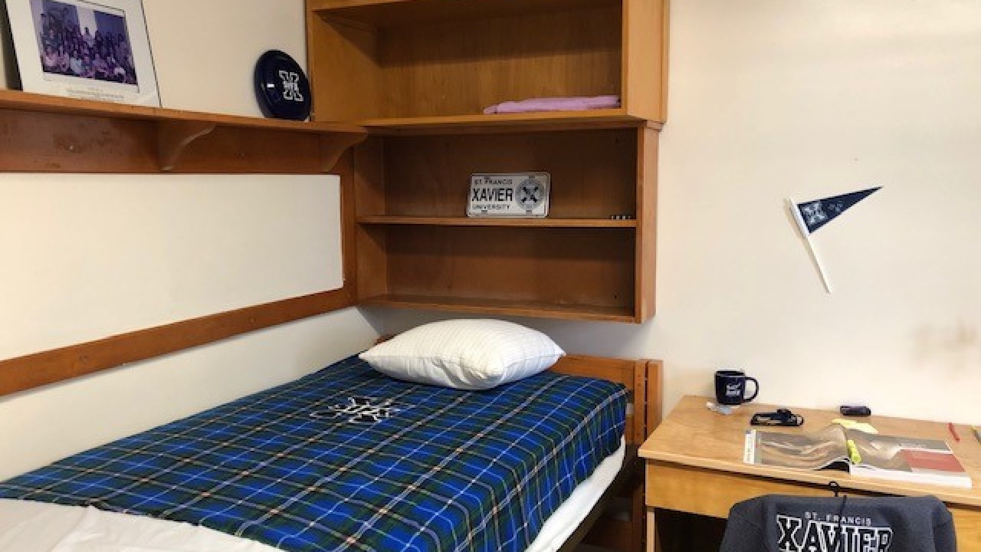 One side of a double room with bed, desk and storage 