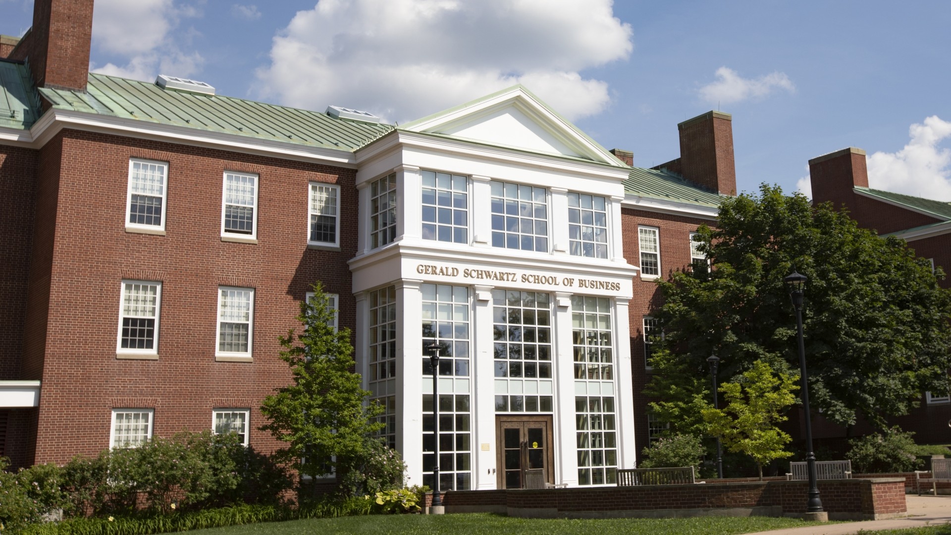 Exterior main entrance of Gerald Schwartz School of Business on a cloudy day.