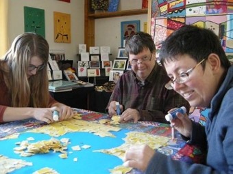 three people doing crafts on table