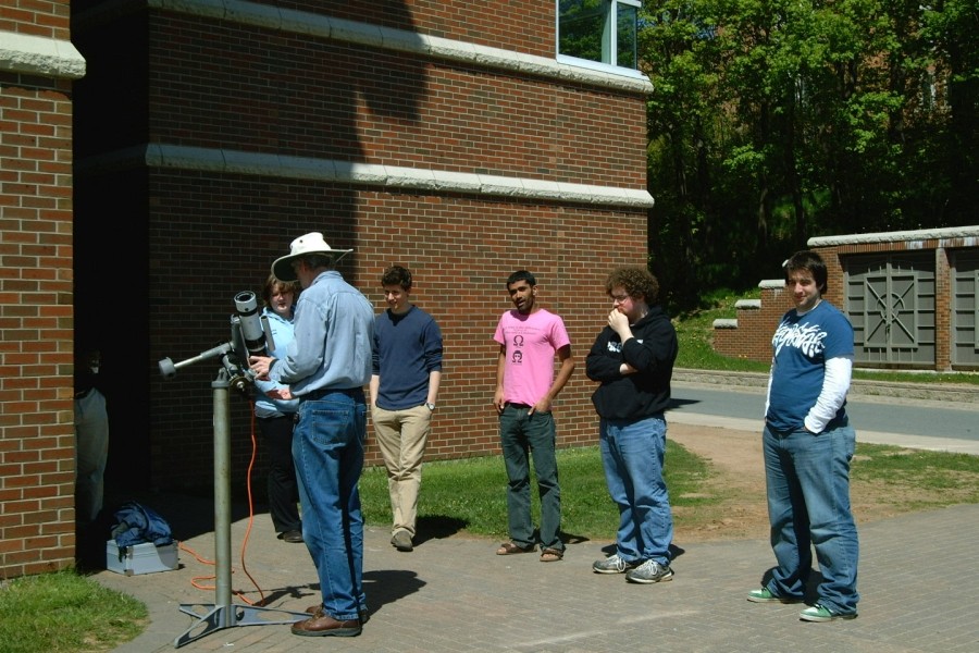 May 2010: Jamie Powell (with hat) lures our students away from their work with observations of the sun just outside the physics building. Students from left to right: Victoria, James R., Ben S., Colin, and Aaron.