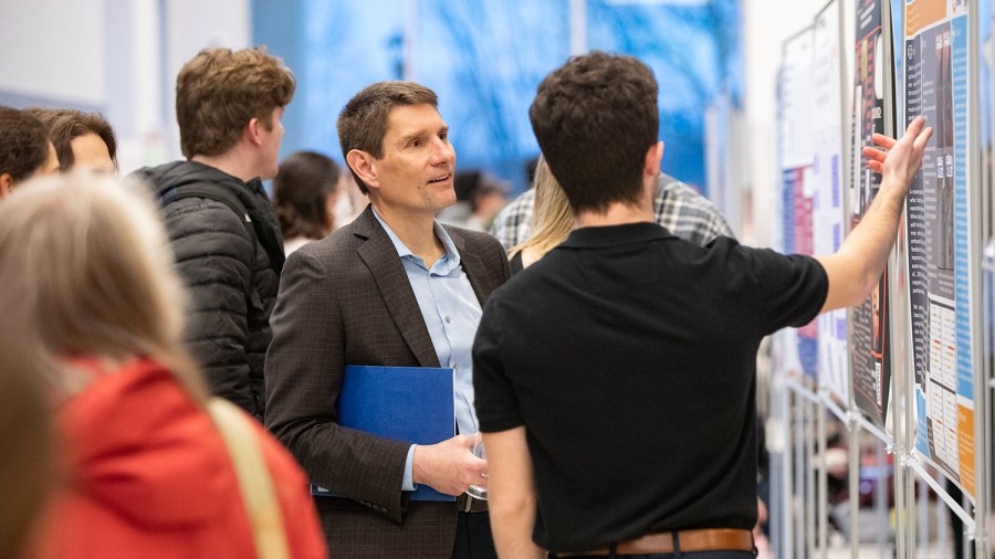 A group of people looking at a poster