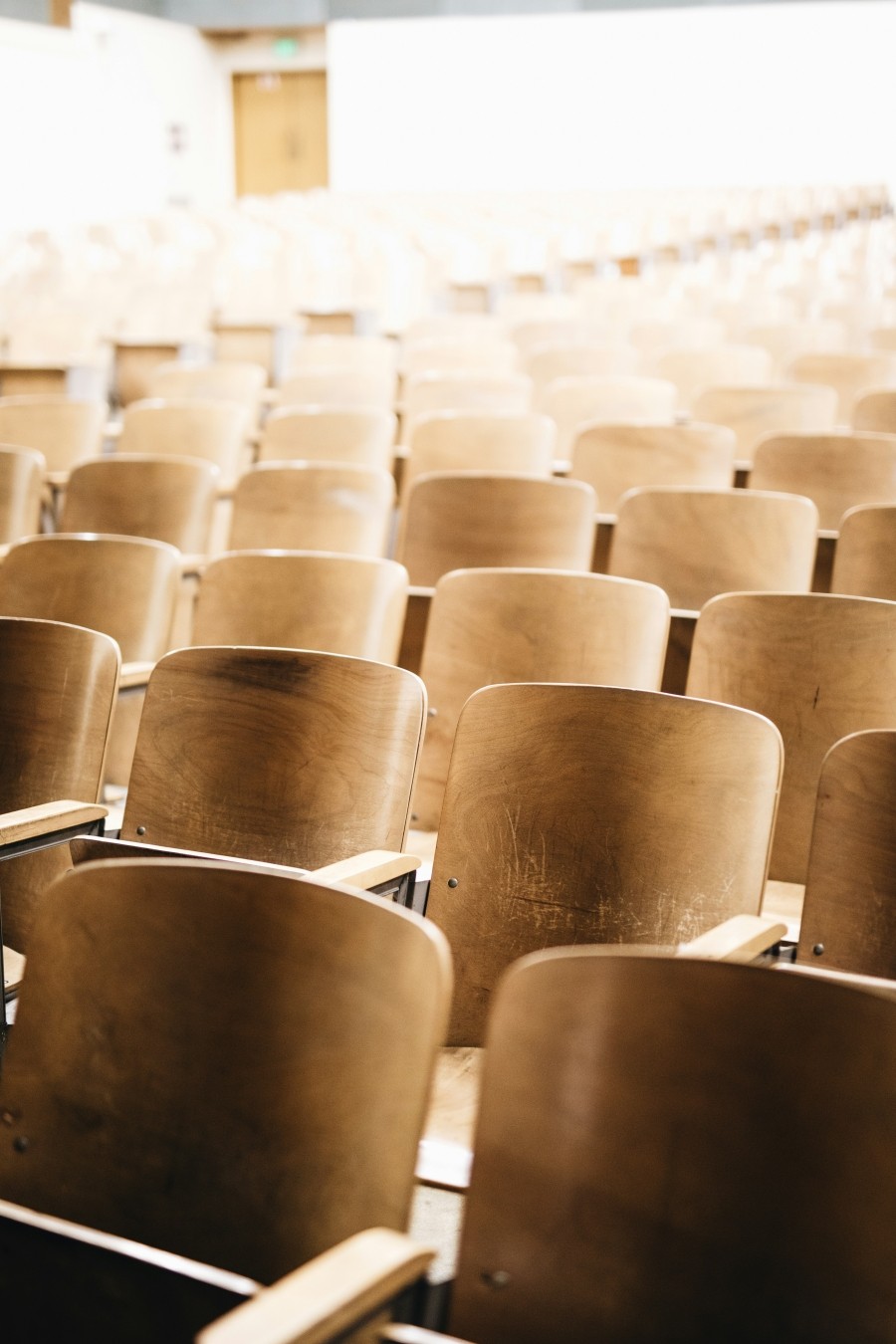 Rows of wooden chairs in a classroom.