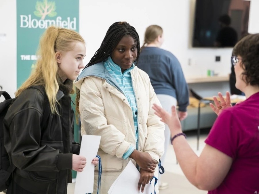 students talking to a department at the on campus job fair