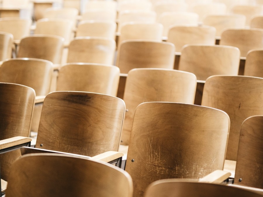 Rows of wooden chairs in a classroom.
